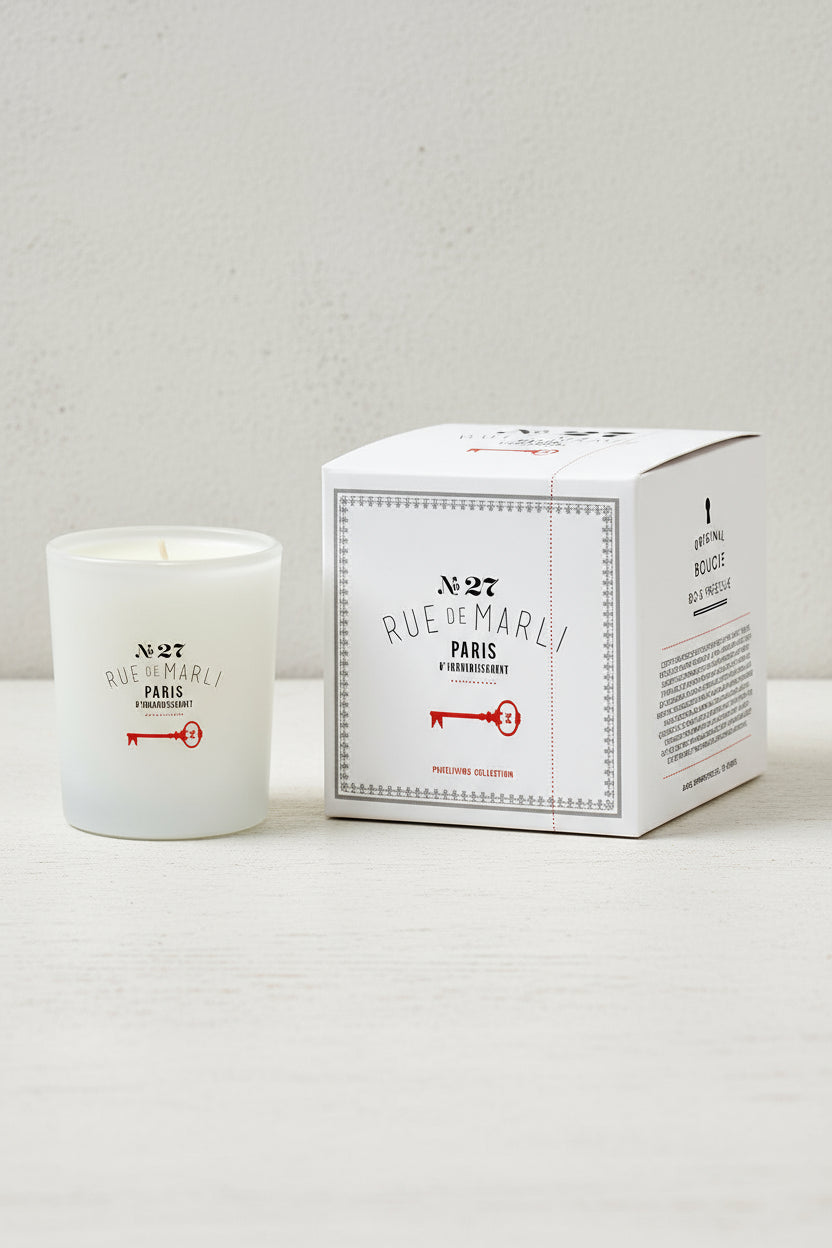 Candle with packaging featuring 'Rue de Marli' branding on a white background