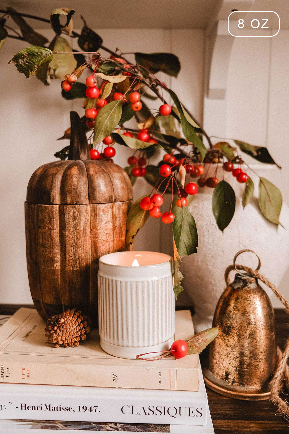 8 oz Spiced Cranberry Christmas Candle by Mimi & August and decorative box on books with a branch of berries 