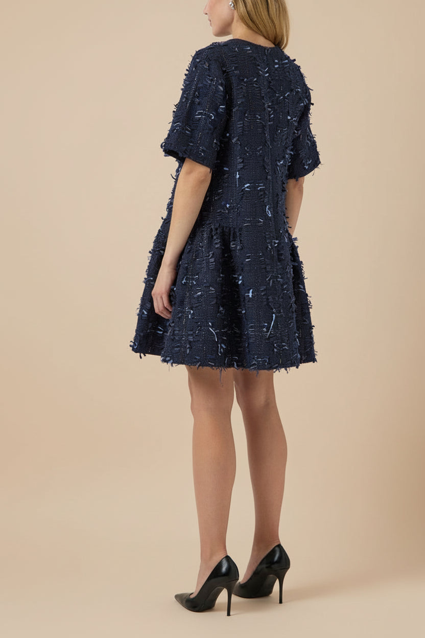 back view of a woman wearing Coralyne Navy Tweed V-Neck Mini Dress from Boutique 1861