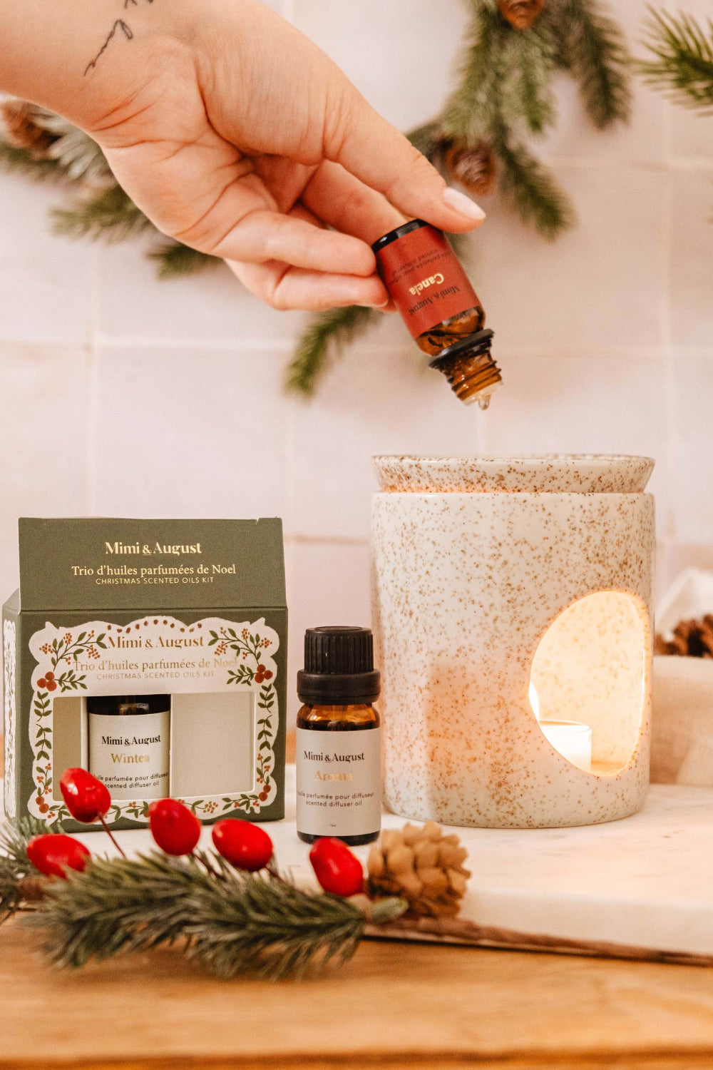 Christmas Scented Oils Trio by Mimi and August in a decorative box on a beige surface with Christmas decorations.