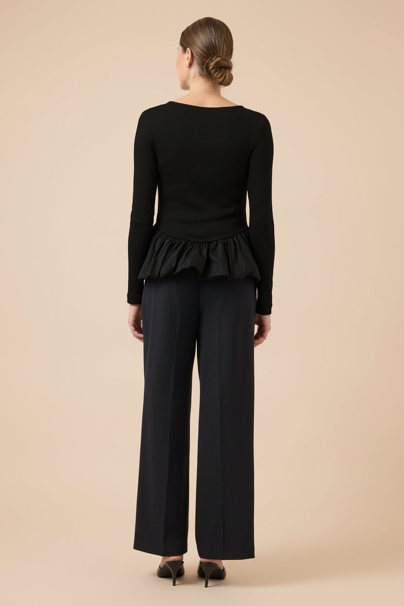 back view of a woman wearing Henrieta Black Fitted Top with Peplum from Boutique 1861 