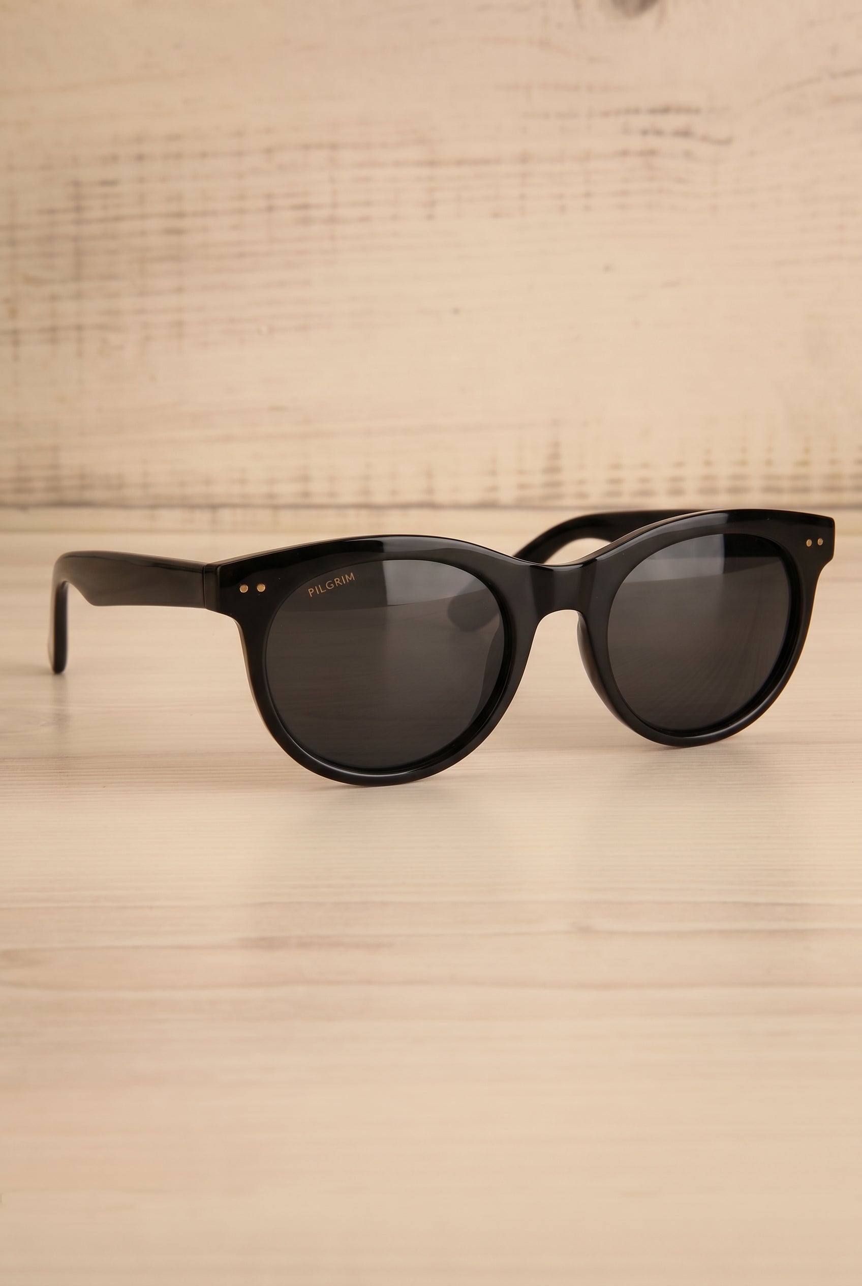 Profile studio view of Jelena Black Circular Sunglasses by Pilgrim at la petite garçonne