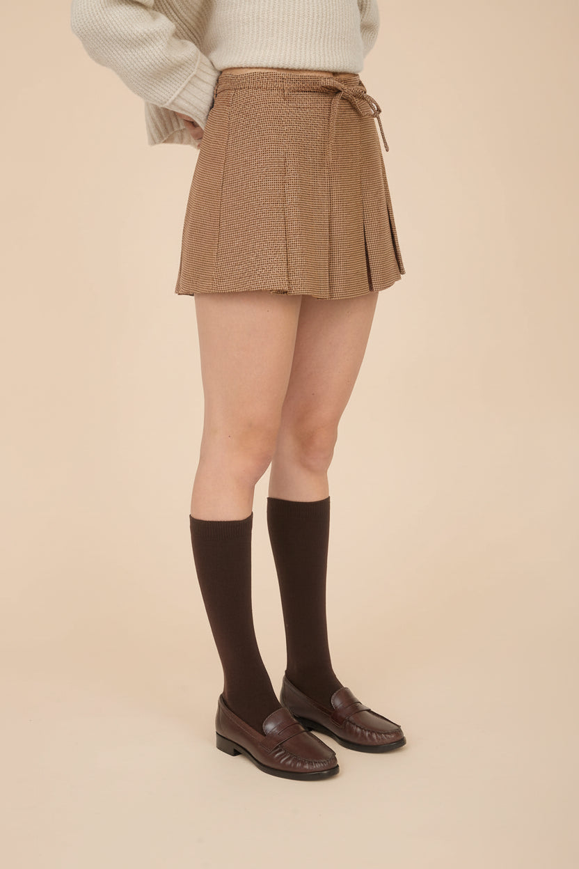 side of a woman wearing Kohima Brown Houndstooth Mini Skirt with Built in Shorts from La petite garçonne