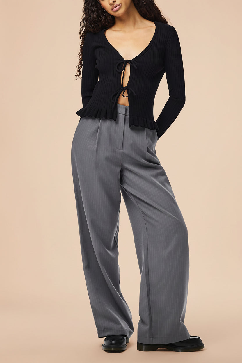 open front view of a woman wearing Lortona Black Ribbed Knit Cardigan with Front Tie and Frill Details from La petite garçonne