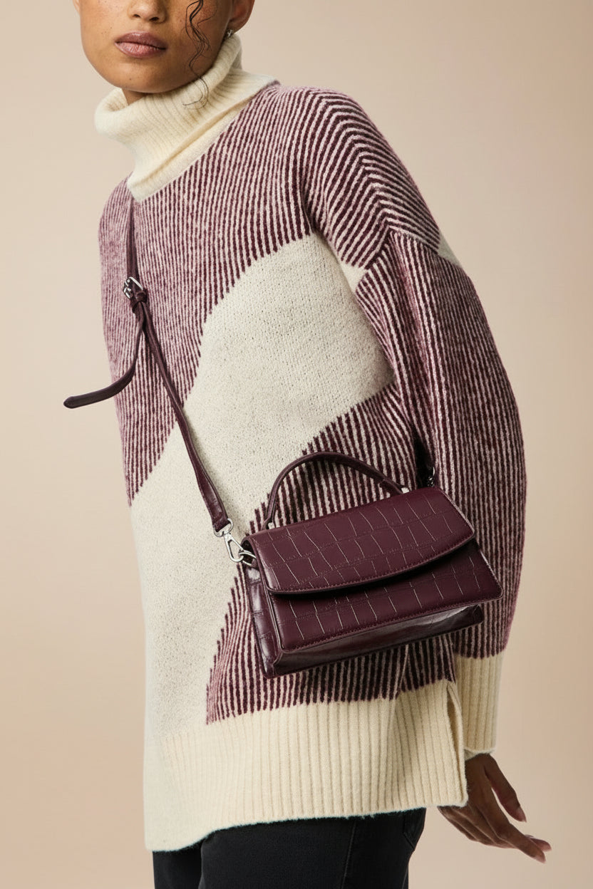 sideview of a Person wearing the snakeskin Burgundy handbag named Mackay from la petite garçonne