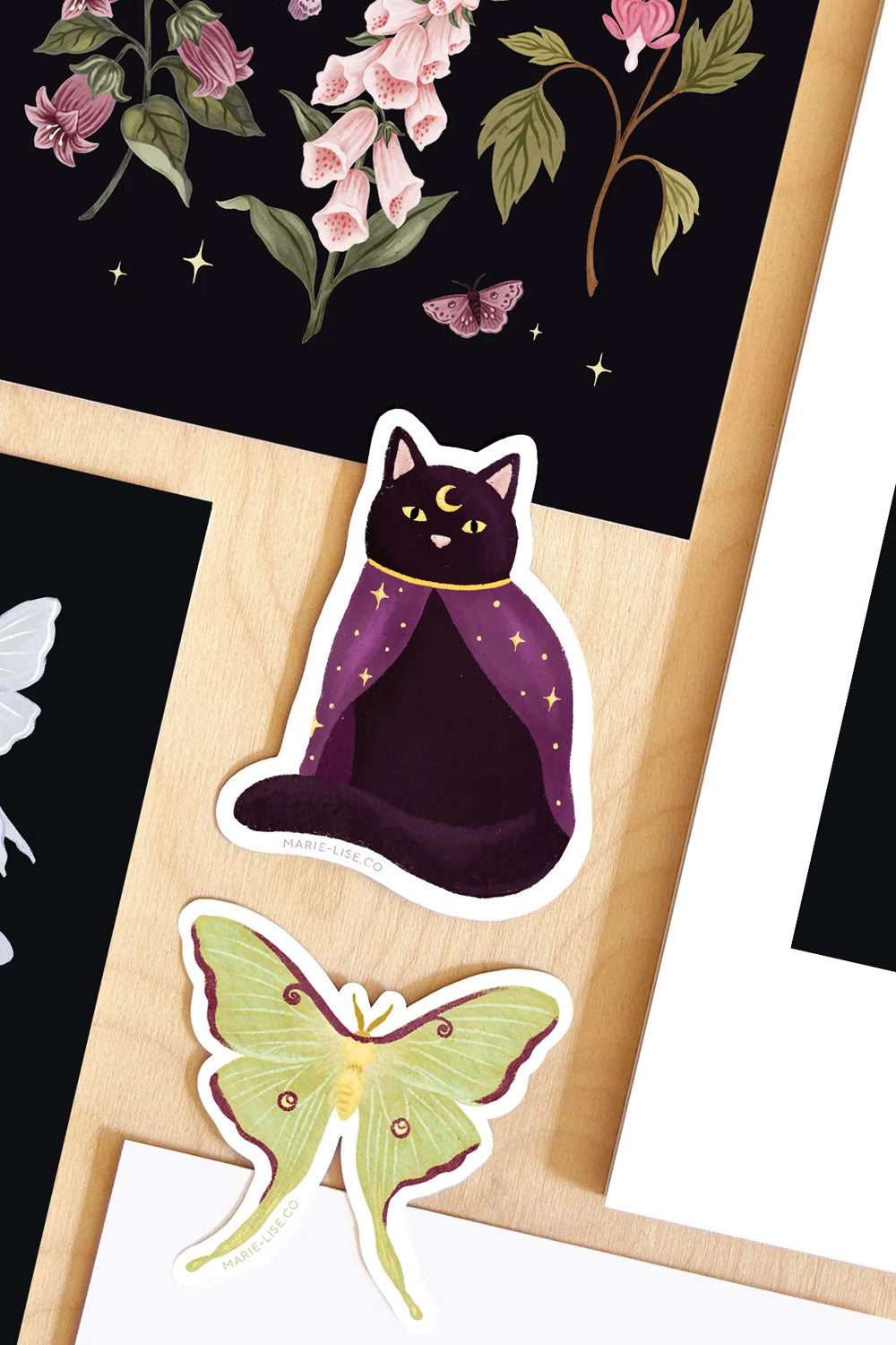 Sticker of a cat in a purple robe and a butterfly on a wooden stand with a black background featuring flowers and stars.