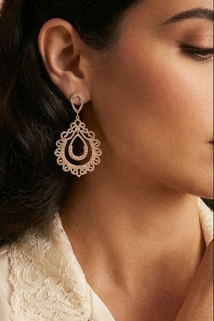 Woman wearing elegant gold rhinestone layered teardrop dangle earrings shimmer with intricate, lace-like sparkle from boutique 1861