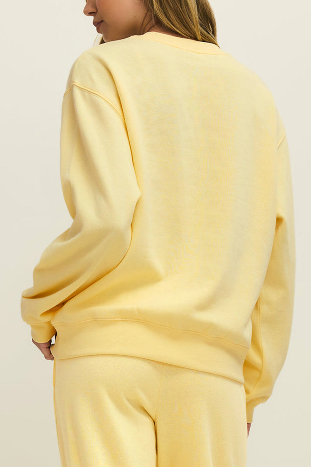 back view of a woman wearing Nesna Yellow Oversized Sweatshirt from La petite garçonne 