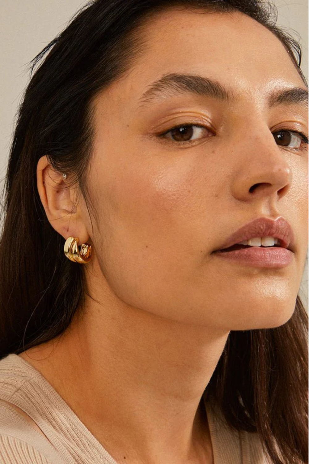 Close-up of a woman wearing gold hoop earrings named Norit gold from Pilgrim 