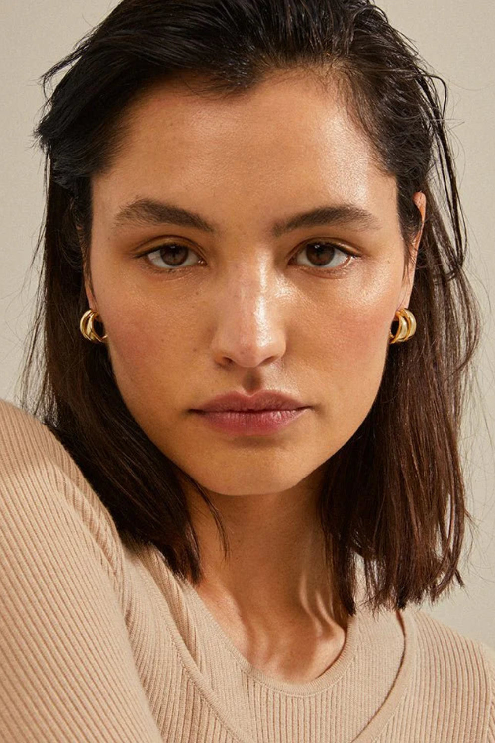 Front view of a woman wearing gold hoop earrings named Norit gold from Pilgrim 