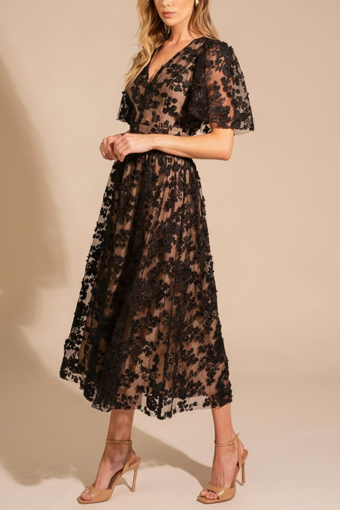Woman wearing the Oukie Black Midi Floral Lace Dress from boutique 1861