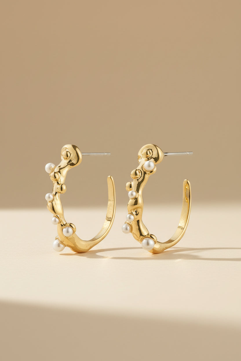 Close-up of Espoo from Pilgrim, a gold hoop earring with small stones available at La petite garçonne in Montreal.