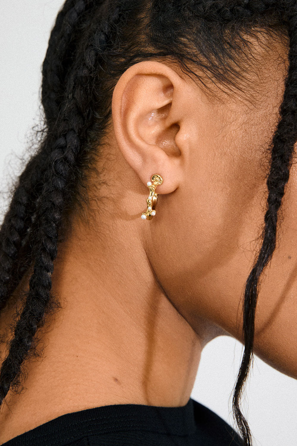 Photo of a woman wearing Espoo from Pilgrim, a gold hoop earring with small stones available at La petite garçonne in Montreal.