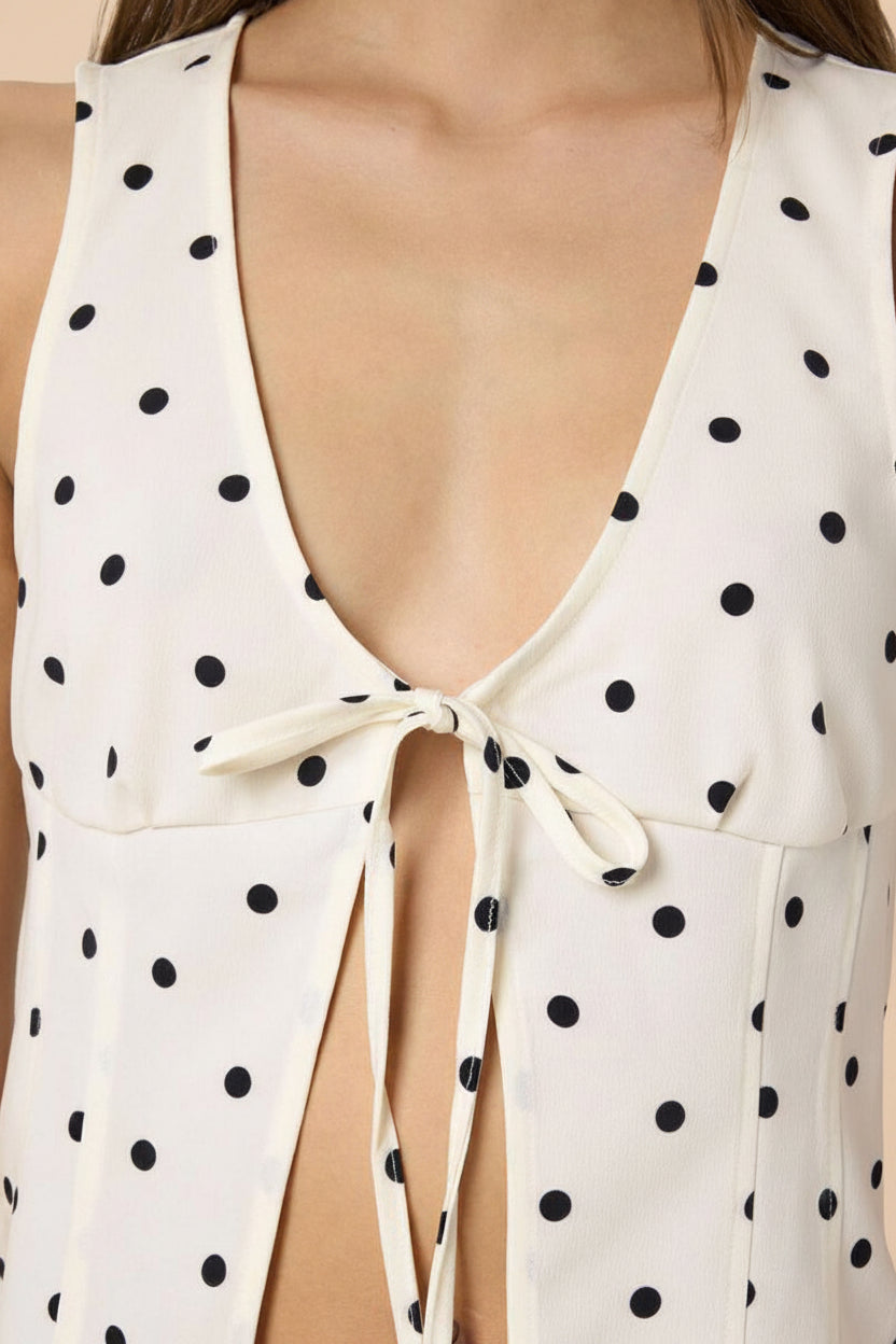 close-up of a woman wearing Raisen Polka Dot Sleeveless White Top with Front Tie from La petite garçonne