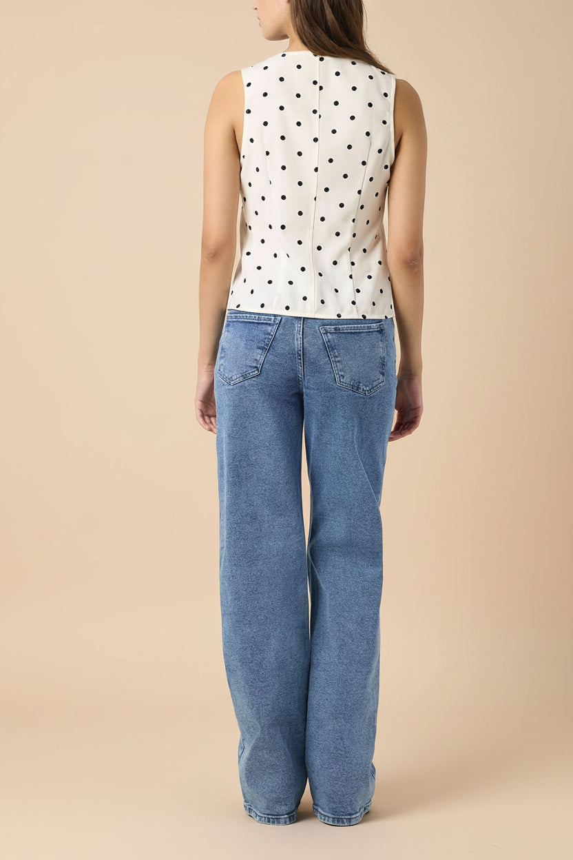 back view of a woman wearing Raisen Polka Dot Sleeveless White Top with Front Tie from La petite garçonne