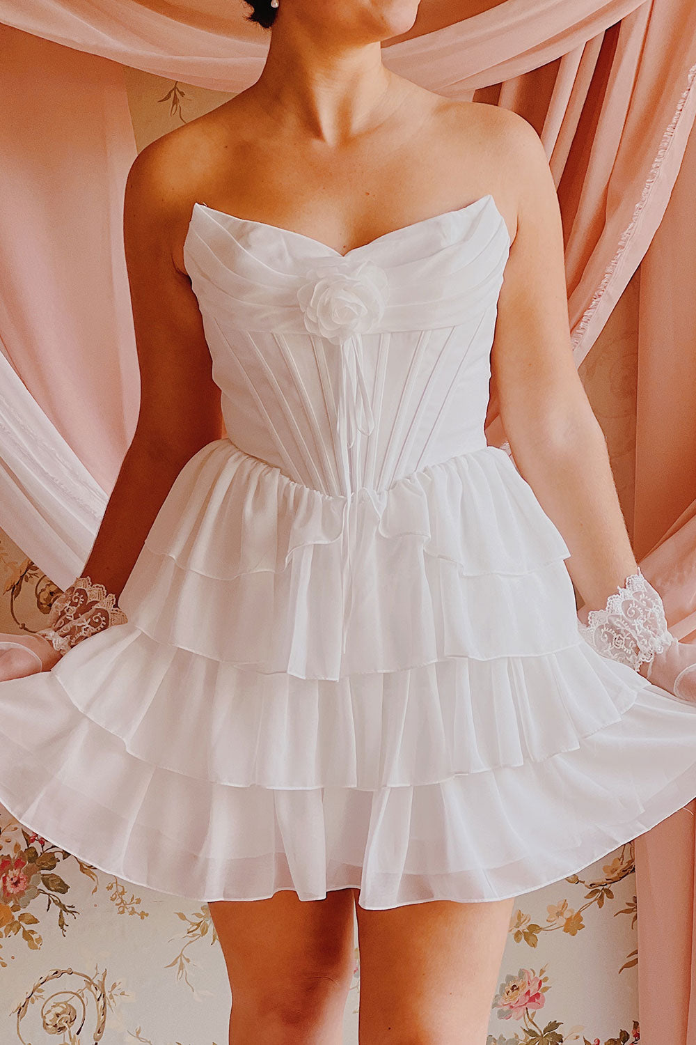 Front view of a Woman wearing Naemia Ivory Strapless Corset Mini Dress with Flower at boutique 1861