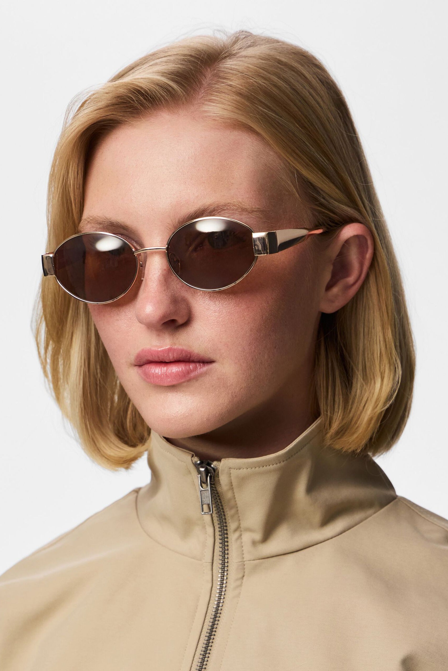 Frontview woman wearing Solstice Gold Oval Sunglasses with Brown Lenses 