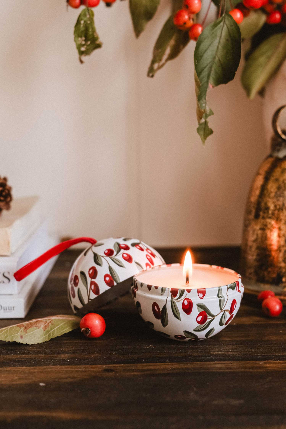Spiced Cranberries Christmas Ornament by Mimi & August on a wooden surface, surrounded by berries and leaves.