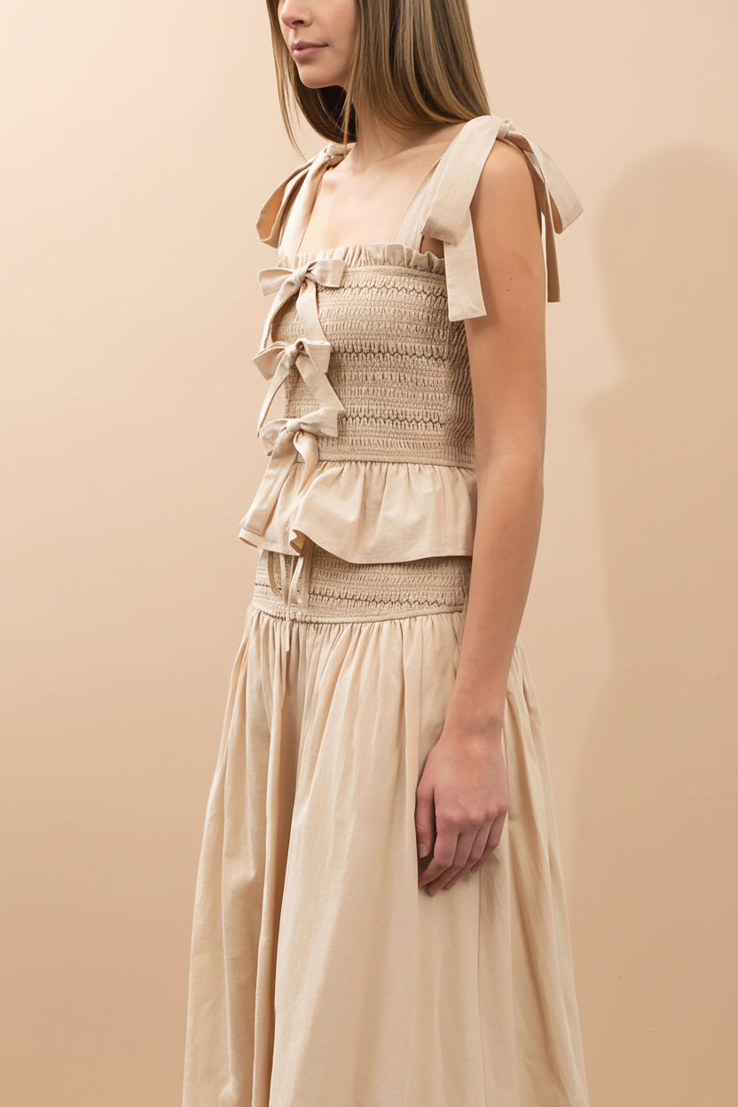 side of a woman wearing Whitney Beige Ruched Top with Bows from Boutique 1861