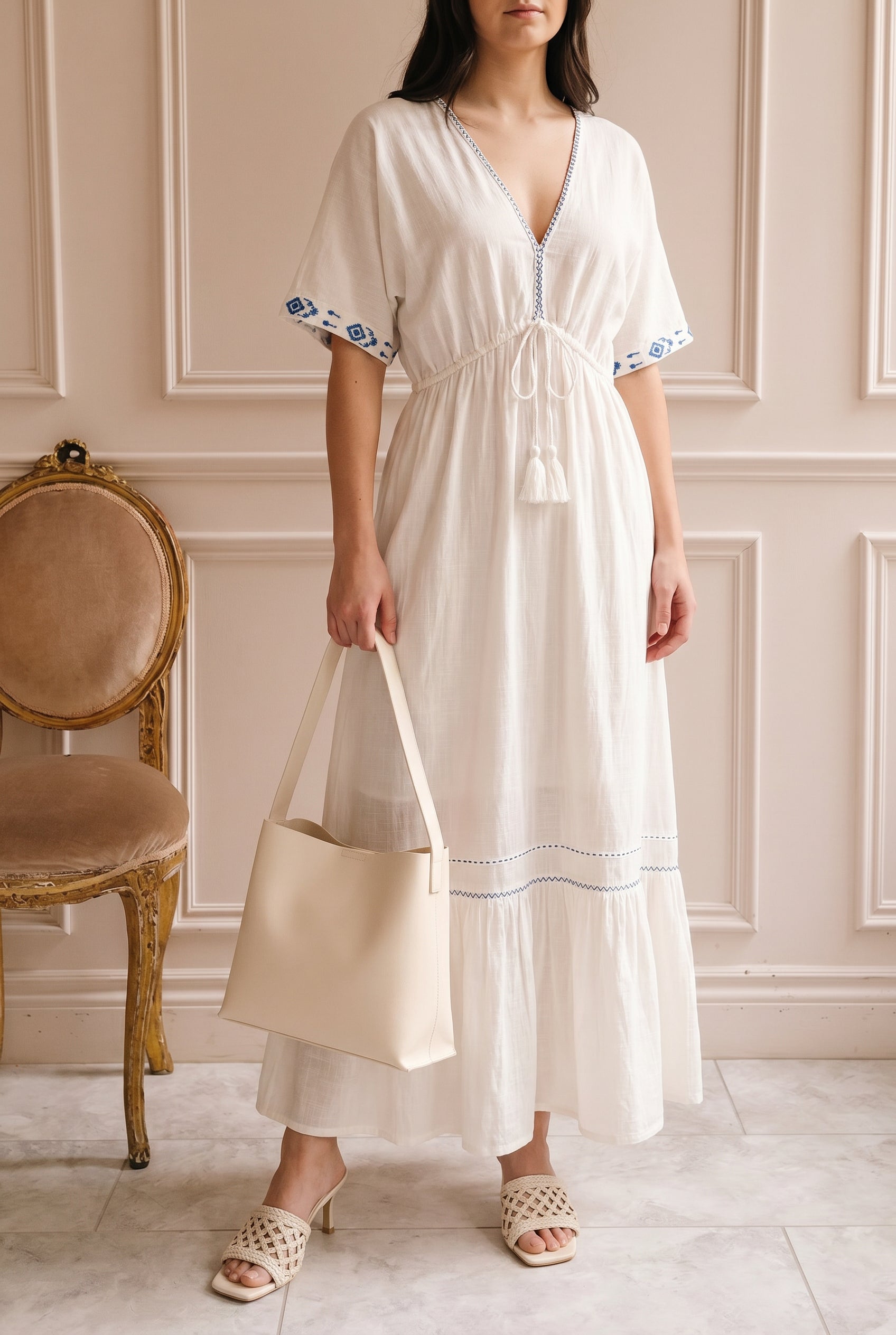 Woman wearing Georgette Embroidered White V-Neck Maxi Dress with Tassel Tie at boutique 1861
