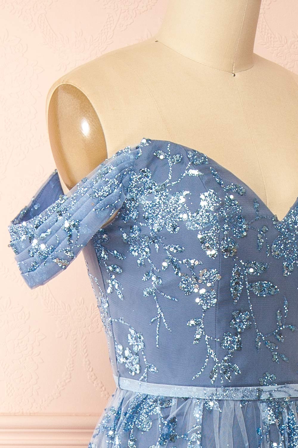 side of sewing mannequin wearing Alienor Blue Grey Glittery Off the Shoulder Maxi Dress from Boutique 1861