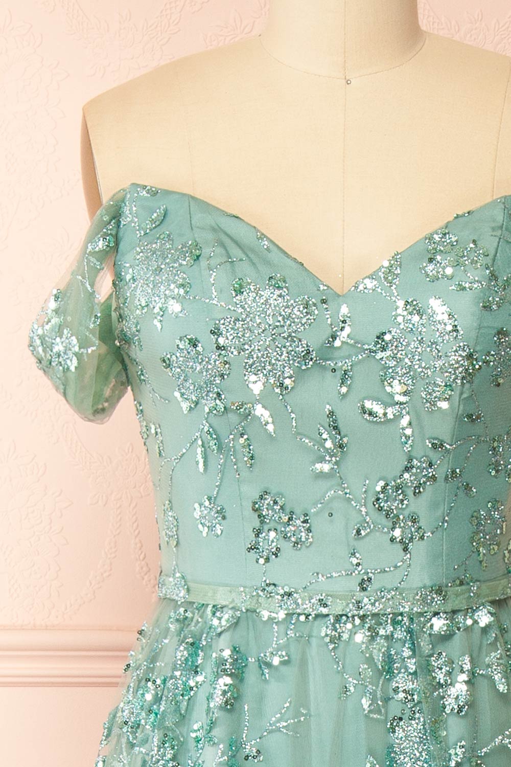front of sewing mannequin wearing Alienor Teal Glittery Off the Shoulder Maxi Dress from Boutique 1861
