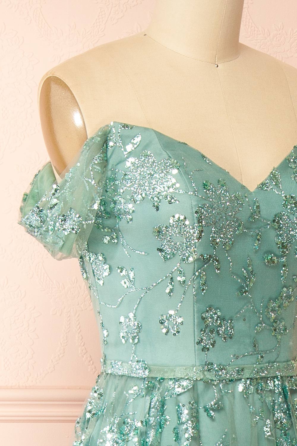 side of sewing mannequin wearing Alienor Teal Glittery Off the Shoulder Maxi Dress from Boutique 1861