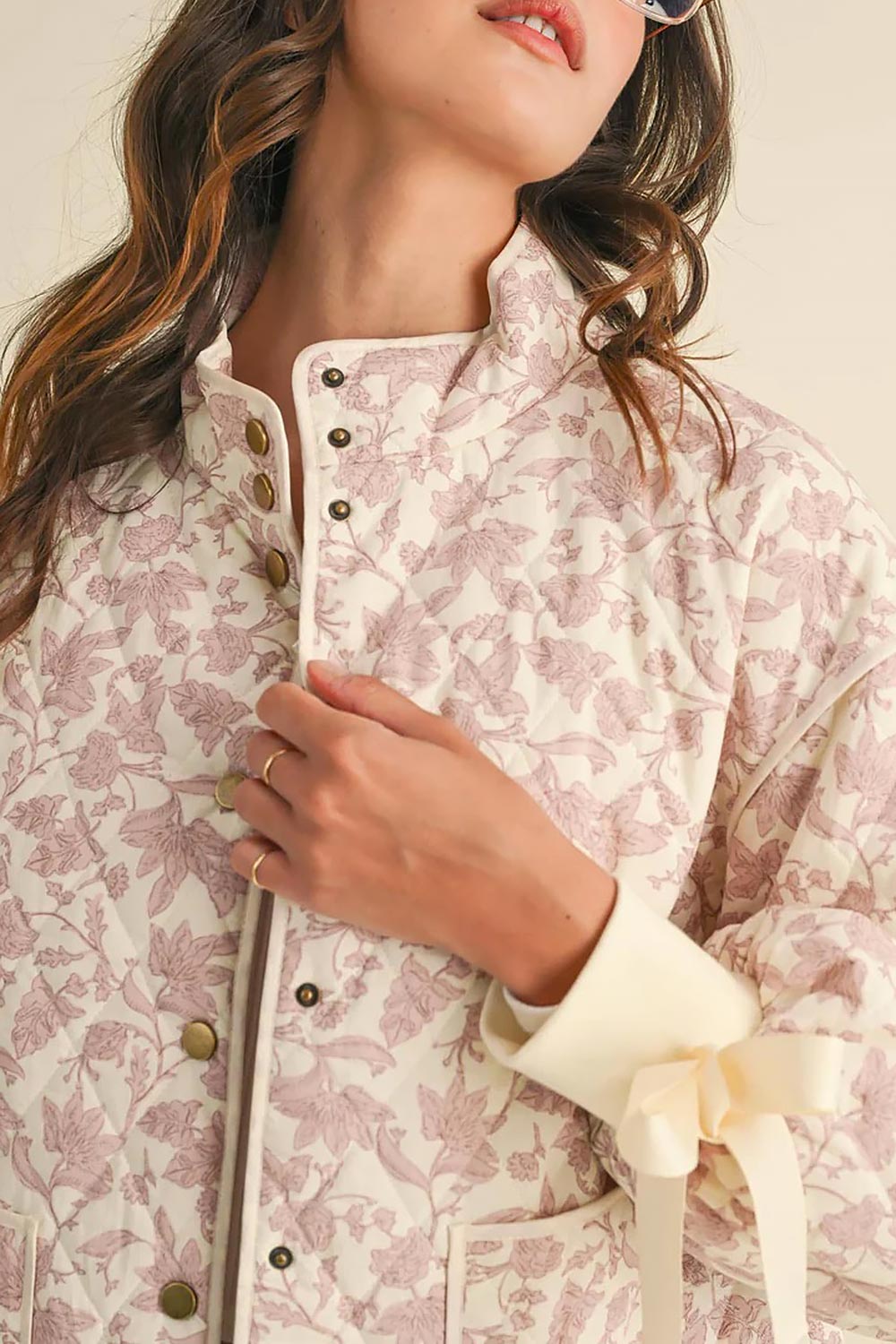 close-up of a woman wearing Anabeth Pink Floral Quilted Jacket with Ribbon-Tied from Boutique 1861