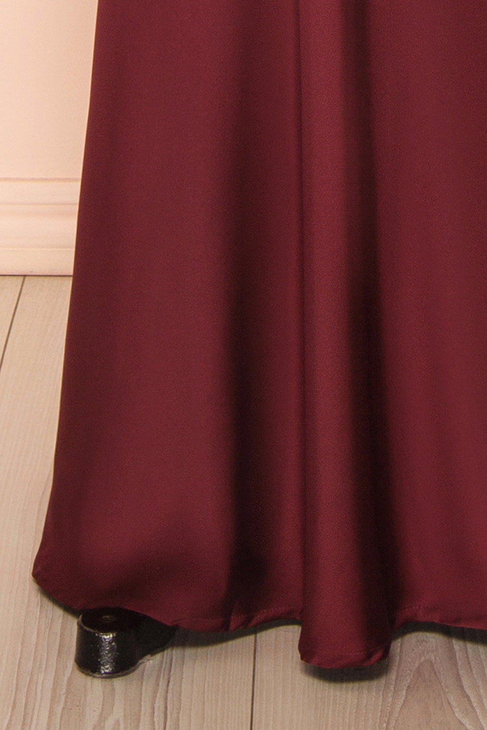 bottom of mannequin wearing Colleen Burgundy Asymmetrical Satin Dress from boutique 1861