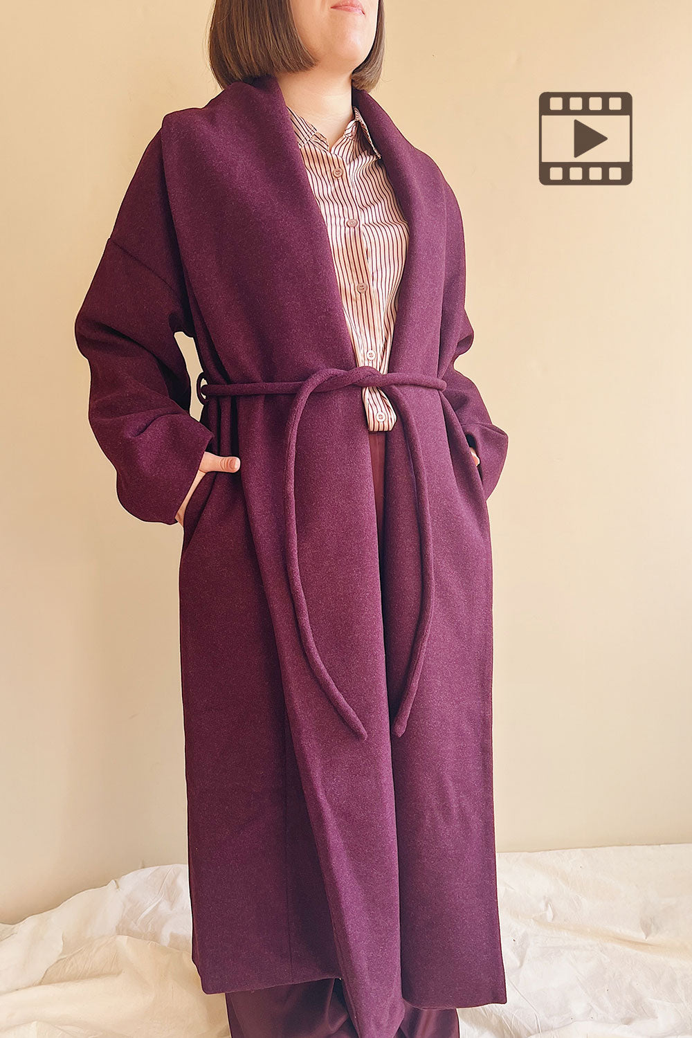 Model wearing Padua, a long Burgundy coat with a belt