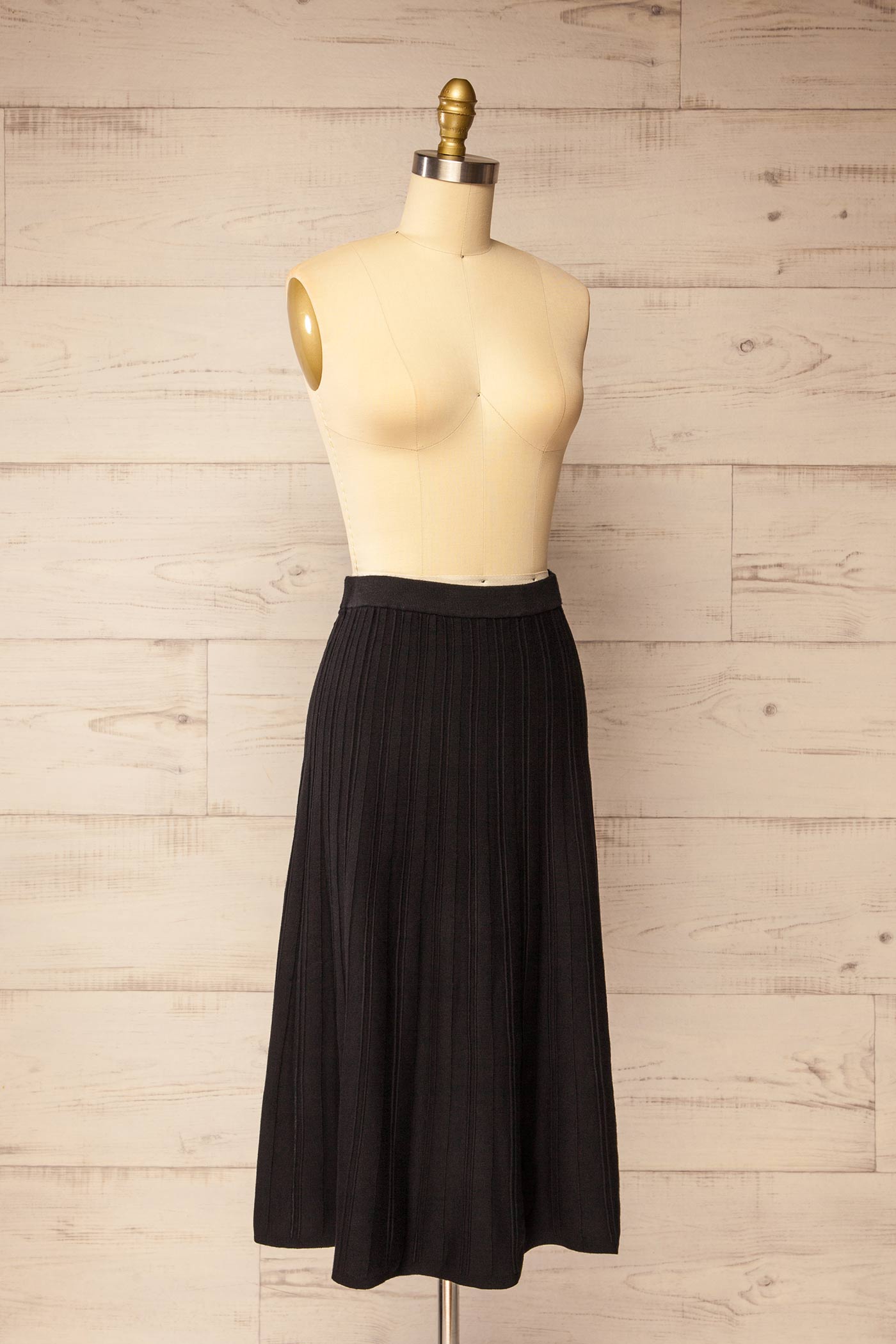 side view of Devonport Black High-Waisted Ribbed Knit Midi Skirt at La petite garçonne