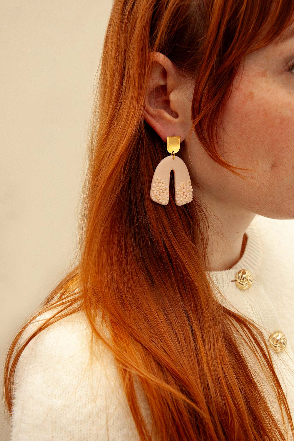 woman wearing Dorothée Blush U Shaped Pendant Earrings with Floral Detail from La petite garçonne 