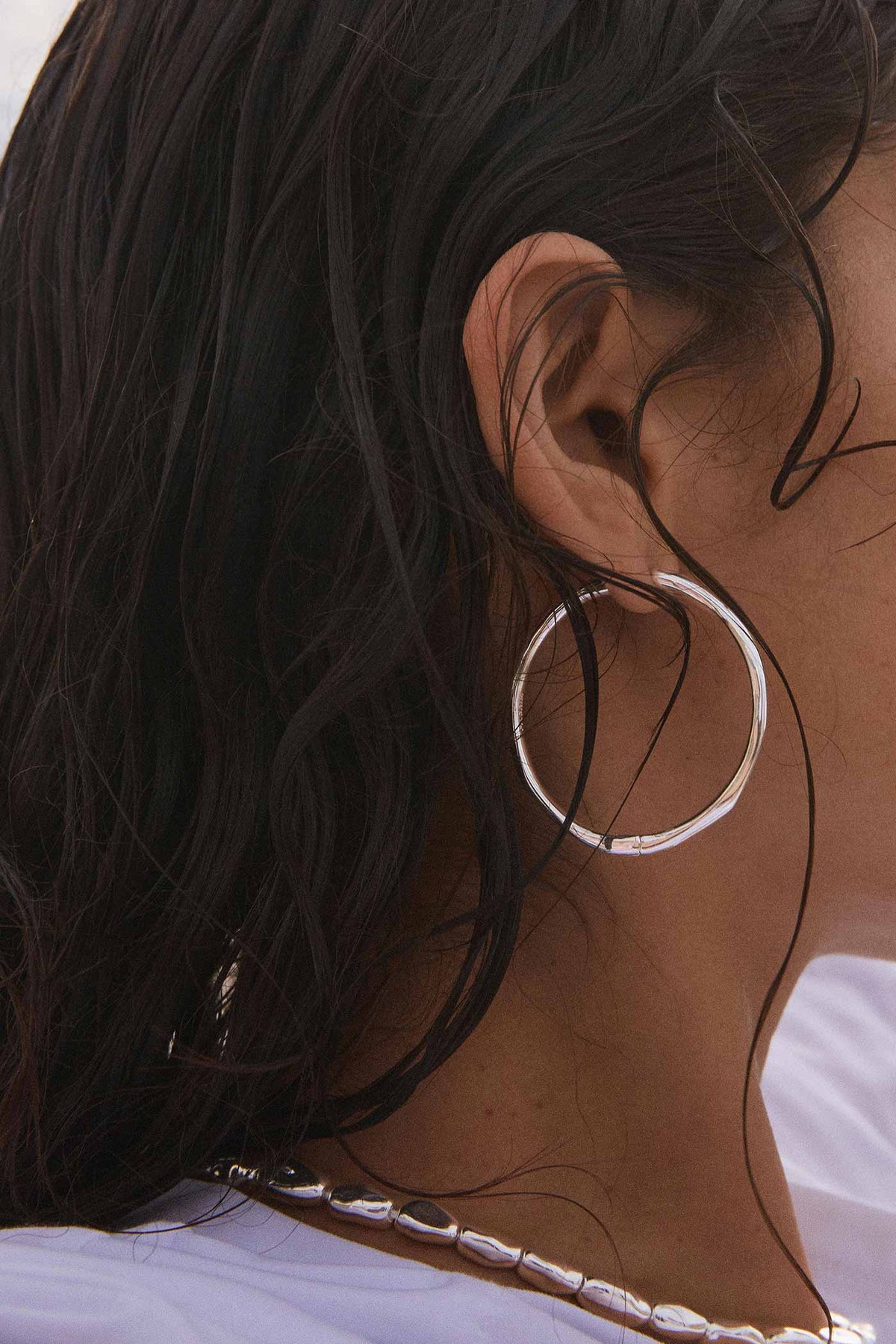 lifestyle shot of a woman wearing Edelia Silver Wave Hoop Earrings by Pilgrim from La petite garçonne