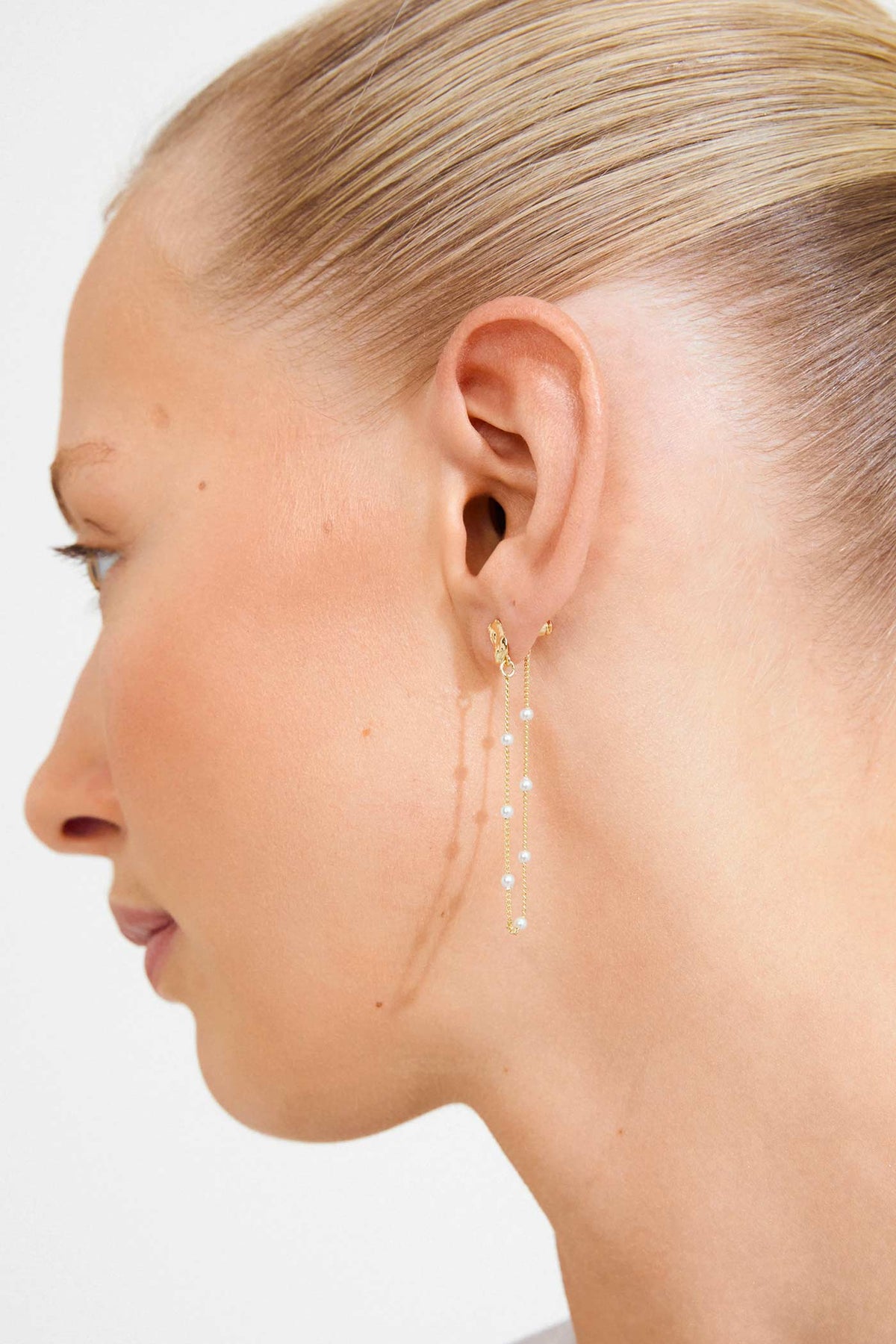 close-up of a woman wearing Farida Gold Loop Chain Earrings with Pearls by Pilgrim from La petite garçonne