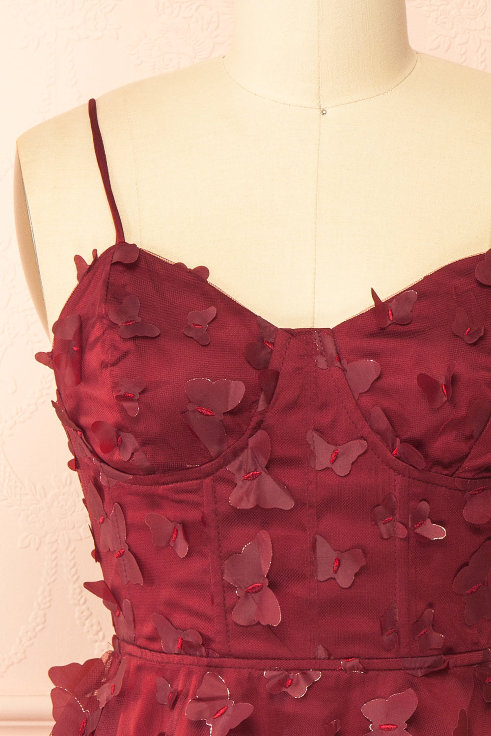front of a sewing mannequin wearing Faya Burgundy Short Corset Dress with Butterflies from Boutique 1861