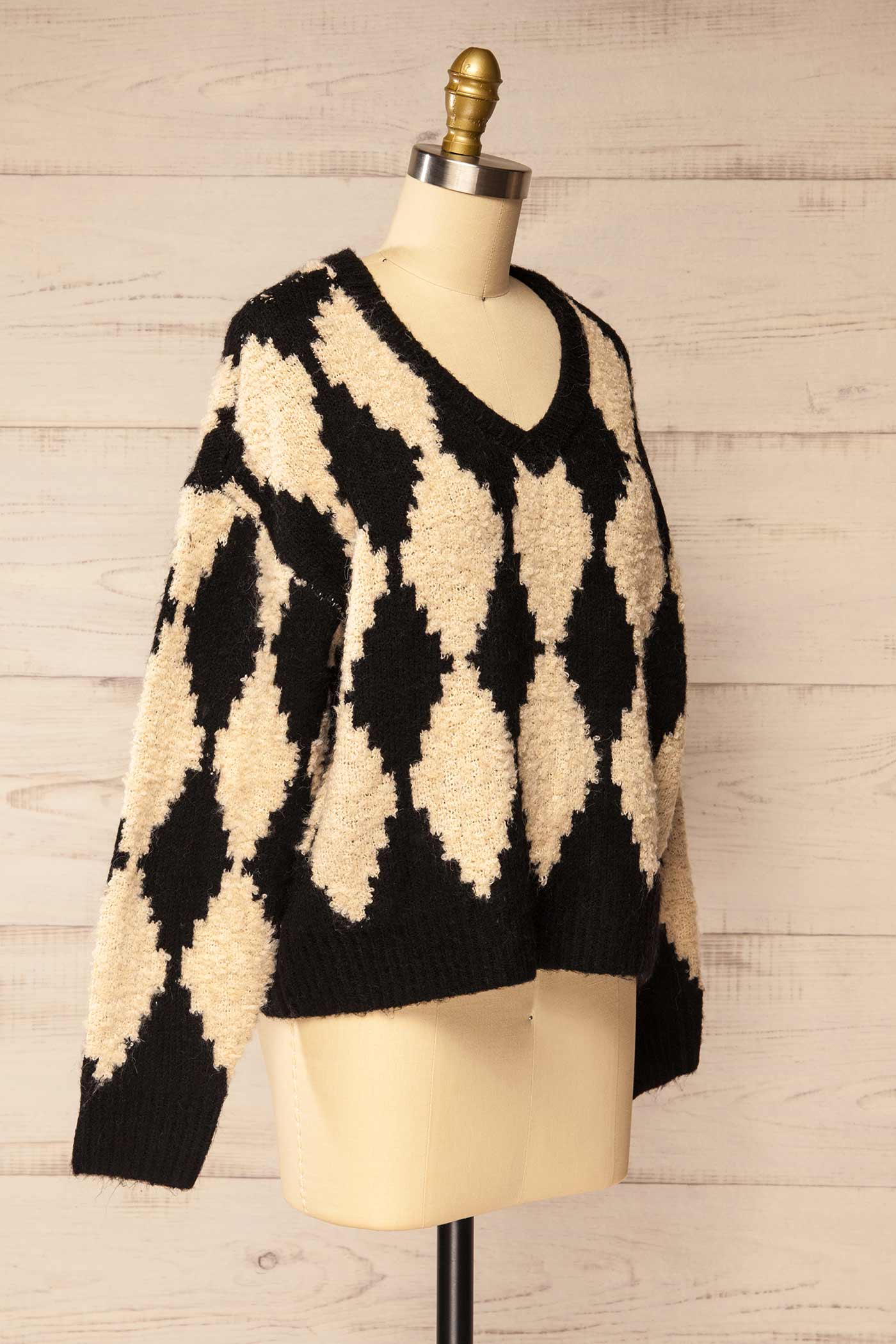 side view of Gawler Black Oversized Argyle V-Neck Knit Sweater at La petite garçonne
