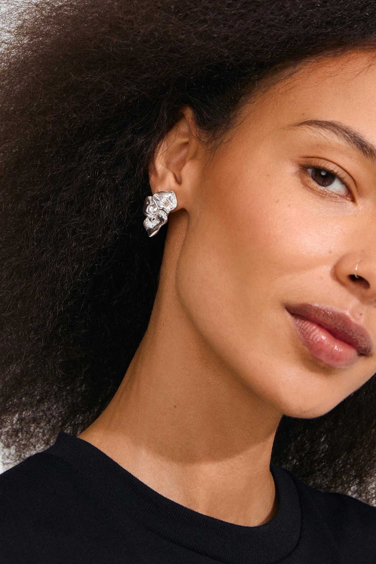 close-up of a woman wearing Halua Silver Large Petal Stud Earrings by Pilgrim from La petite garçonne