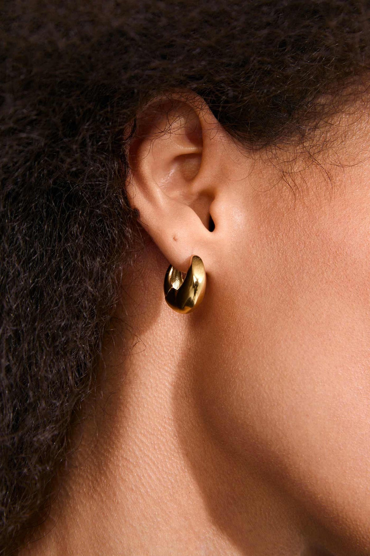 close-up of a woman wearing Ignis Gold Small Chunky Hoop Earrings by Pilgrim from La petite garçonne