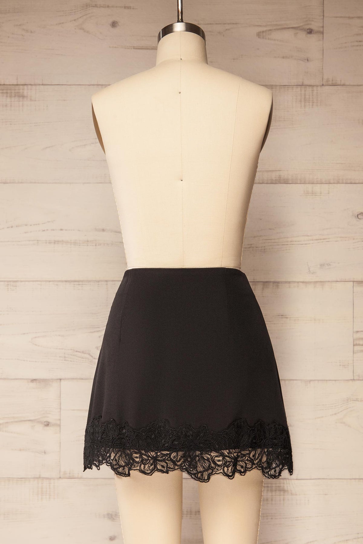 back view of Imilda Black Lace-Trim Mini Skirt with Built-In Shorts at La petite garçonne