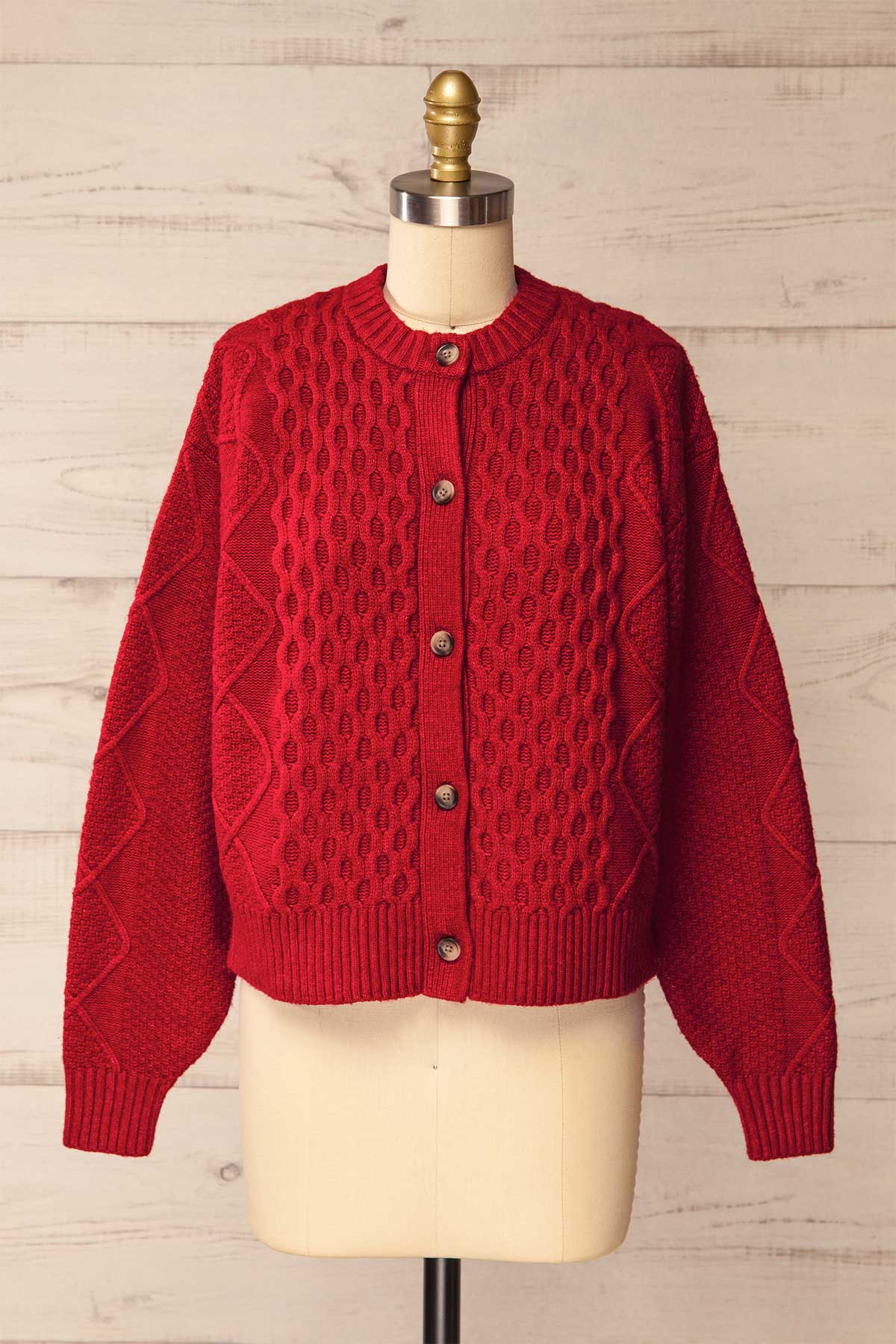 front view of Oyama Red Cable Knit Button-Front Cardigan at La petite garçonne