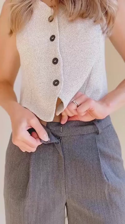 Video of a mannequin wearing the grey pants Akola and the top Indigo in front of a beige background