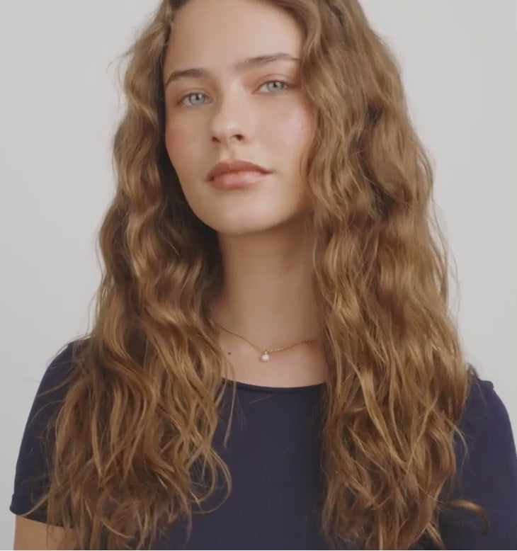 Video of a person wearing a gold necklace GUIDEL-GOLD by Pilgrim with a pearl pendant.