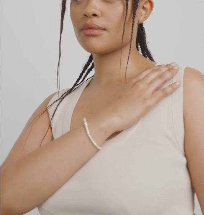 Video of a woman with braided hair wearing a pearl necklace EXETER-GOLD by Pilgrim against a neutral background