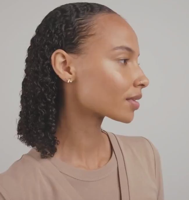 Video of a woman wearing AGLAIA, a gold flower-shaped earring from Pilgrim La petite garçonne Montreal