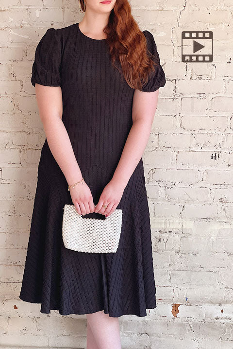 Video on a model wearing the Lenexa Black Midi Dress with Puff Sleeves from La petite garçonne 