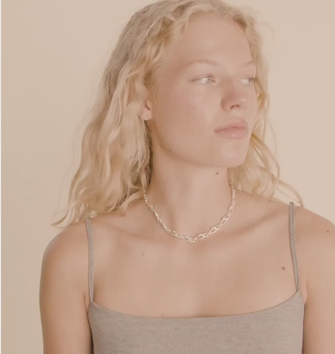 Video of a person wearing a silver chain necklace CHIFENG-SILVER by Pilgrim with a blurred background