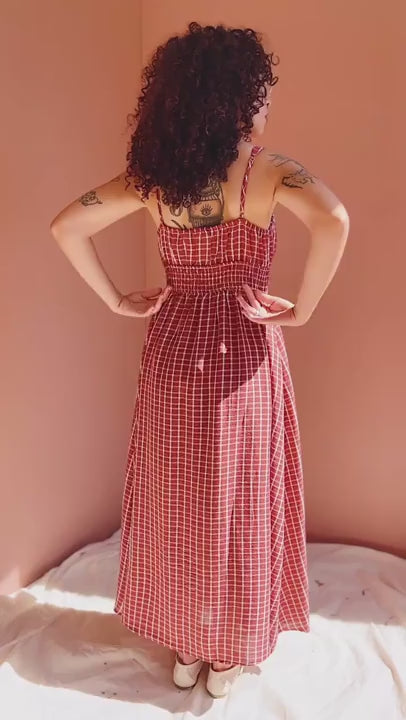 Vidéo of a mannequin wearing the Red checkered dress Kono against a light pink wall.