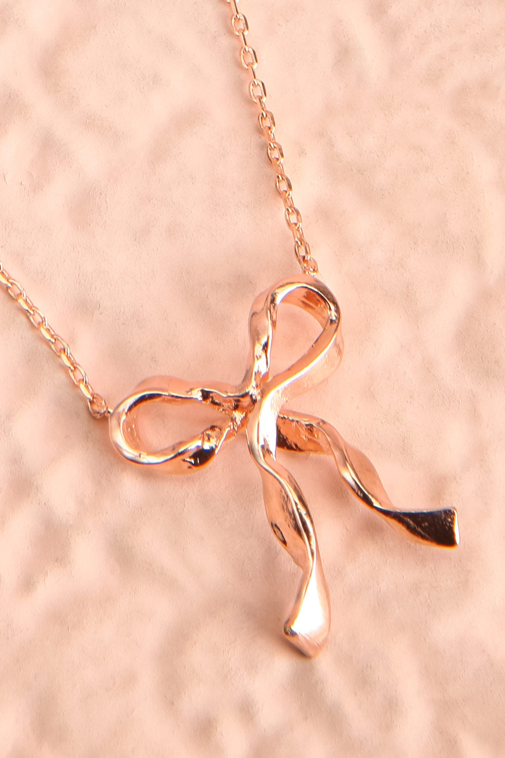 Triteia Rosegold Necklace w/ Bow Charm | Boutique 1861 flat close-up