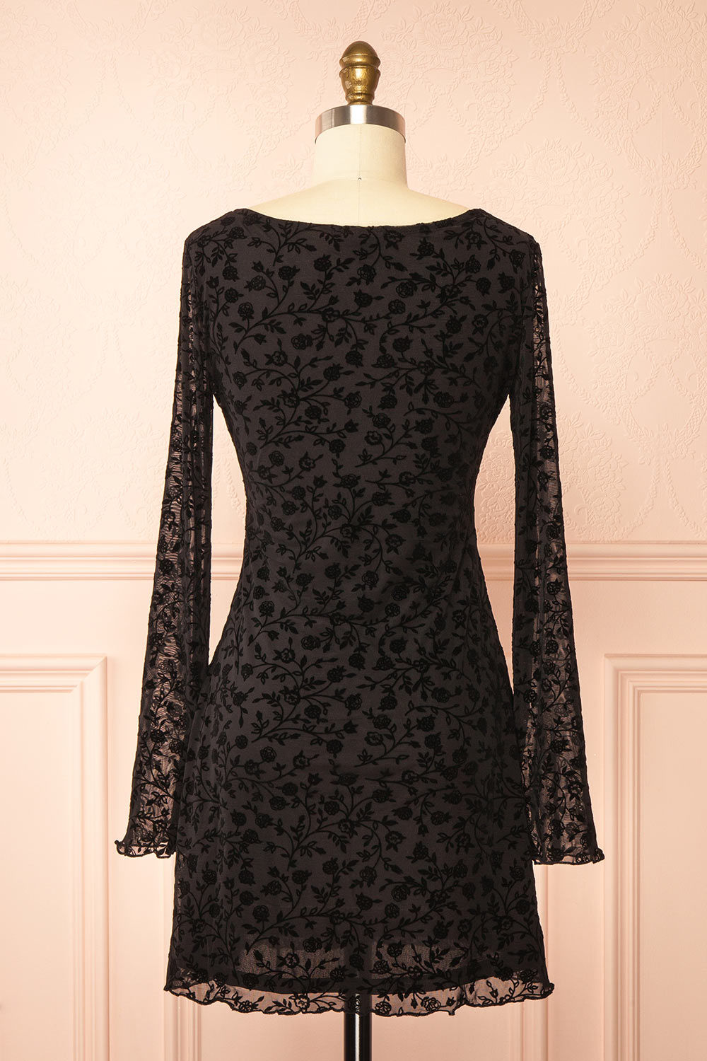 back view of a mannequin wearing a Zoeline Short Long-Sleeved Black Dress from boutique 1861